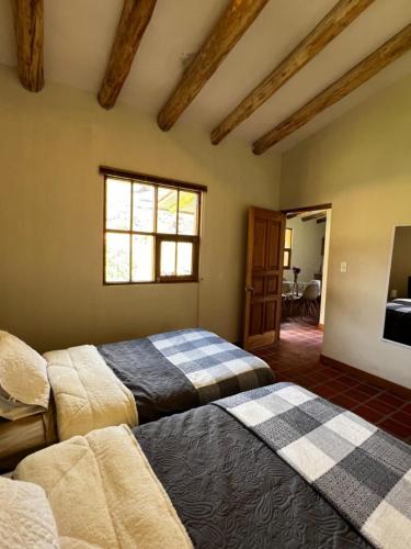 a bedroom with two beds and a window at Bungalow Lamay - Cusco in Lamay