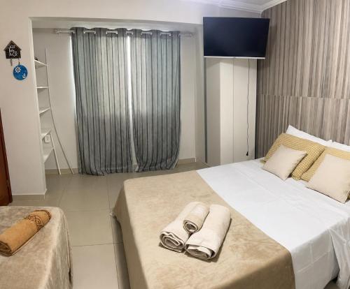 a bedroom with a large bed with towels on it at G2 Hospedagem Suites & Studio Praia Dos Anjos in Arraial do Cabo