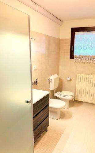 a bathroom with a toilet and a sink at Ciconi Garden Studio Apartment in Gorizia