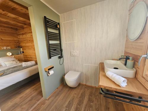 a bathroom with a sink and a toilet and a bed at L'Escapade du Puy in Saint-Amand-sur-Sèvre