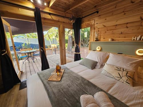 a bedroom with a large bed in a wooden cabin at L'Escapade du Puy in Saint-Amand-sur-Sèvre