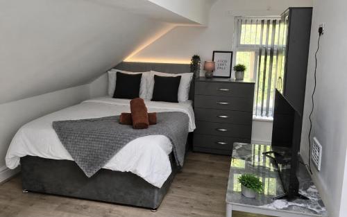 a bedroom with a bed with a teddy bear on it at Northenden Stayzzz in Manchester