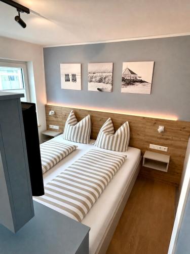 a bedroom with two beds with striped pillows at Inselliebe Norderney in Norderney