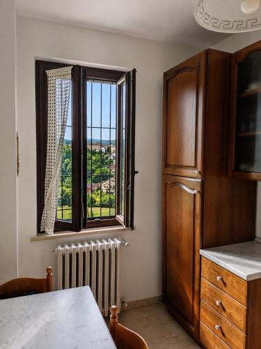 a kitchen with a large window and a radiator at Civico 32 in Mondovì