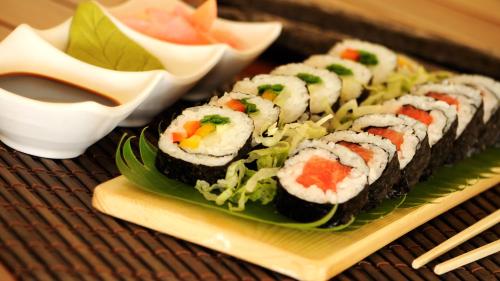 a plate of sushi and a salad on a table at Bigstay in Tada