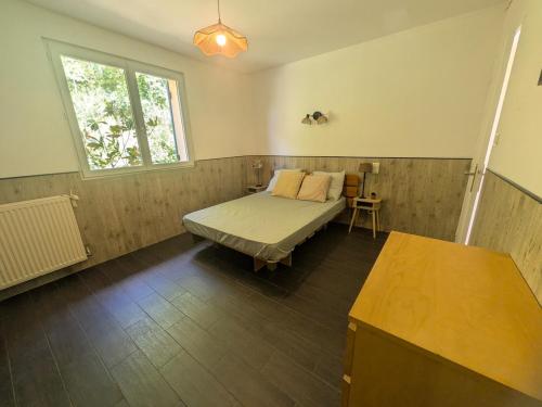 a bedroom with a bed and a window and a table at Le Petit Gîte de L'Étang in Saint-Géry