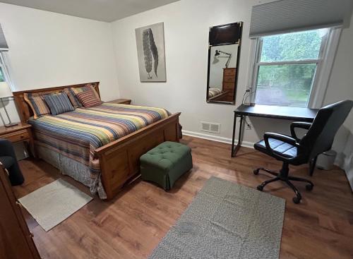 a bedroom with a bed and a desk and a chair at Charming Roanoke Guesthouse in Roanoke
