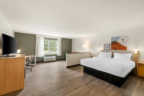 a hotel room with a bed and a flat screen tv at Spark By Hilton Freeport in Freeport