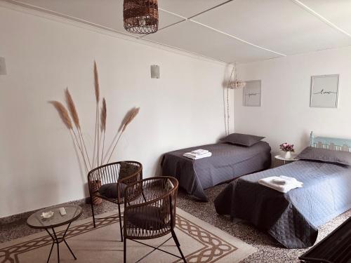 a bedroom with two beds and a table and chairs at Depto Güemes in Río Gallegos