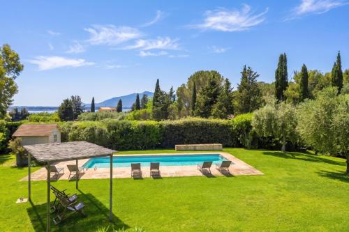 a backyard with a swimming pool and a grass yard at Chalet Vignarola - Happy Rentals in Orbetello