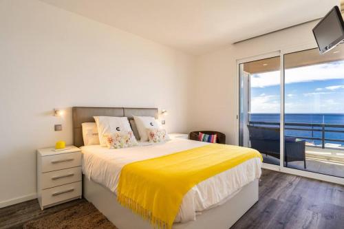 a bedroom with a large bed with a yellow blanket at Monumental Apartments - Multi Listing in Funchal