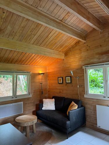 ein Wohnzimmer mit einer Couch und zwei Fenstern in der Unterkunft kemphaan in Appelscha