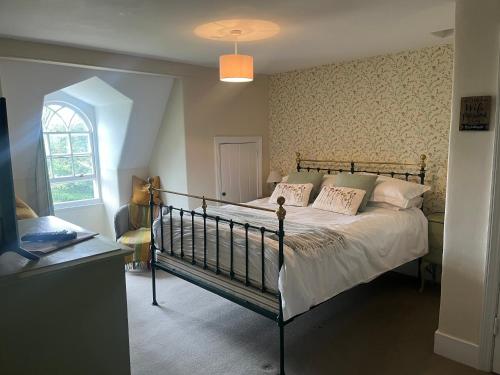a bedroom with a bed and a window at Tor Royal Farm House in Princetown