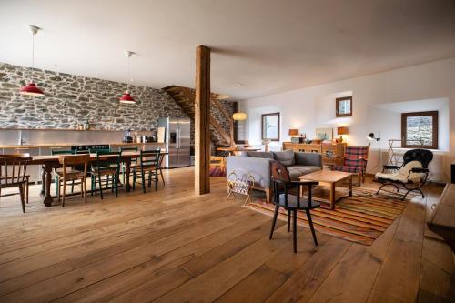 a living room and dining room with a stone wall at Chalet l'Arva in Saint-Marcel