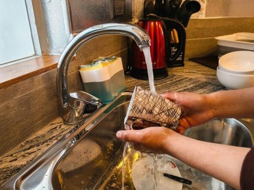 a person is washing a sponge in a sink at Loft de 2 Camas in Callampaya