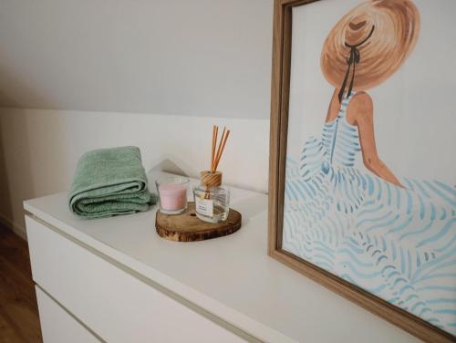 a white dresser with a picture of a woman at Casa Serra & Mar in Azeitao