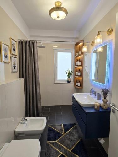 a bathroom with a sink and a toilet at Spacious Central Apartment with Panoramic Views in Tirane