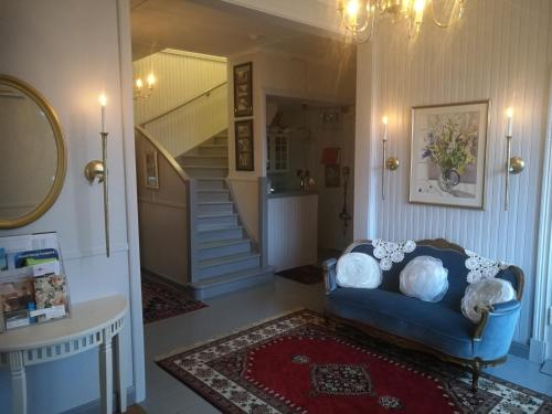 a living room with a blue couch and a staircase at Hotell Floras Trädgård in Öregrund