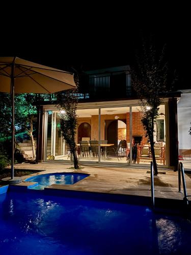a house with a swimming pool at night at Forest Oasis Slatina in Slatina Varoš