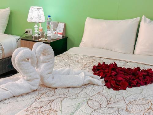 a bed with two towels and a pile of roses at Riti Wasi in Yungay
