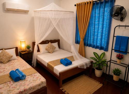 a bedroom with two beds and a canopy bed at SunBeachHouse in Weligama
