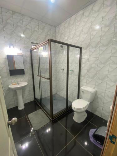 a bathroom with a shower and a toilet and a sink at Casa playa el Retén 