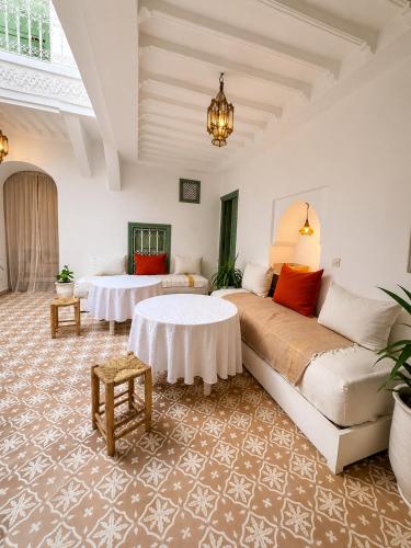 a living room with a large bed and a table at Dar la famille Marrakech in Marrakesh
