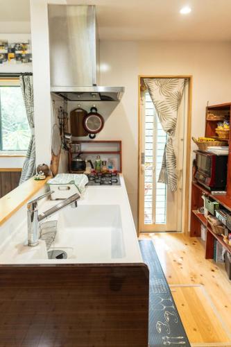 a kitchen with a sink and a stove at 今帰仁森風テラス in Nakijin