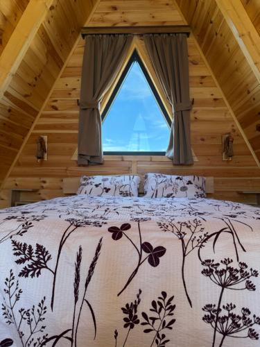 a bedroom with a large bed with a window at Hedwig cottages 2 in Žabljak