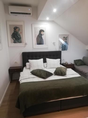 a large bed in a room with pictures on the wall at Apartments Simple Teslina in Zagreb
