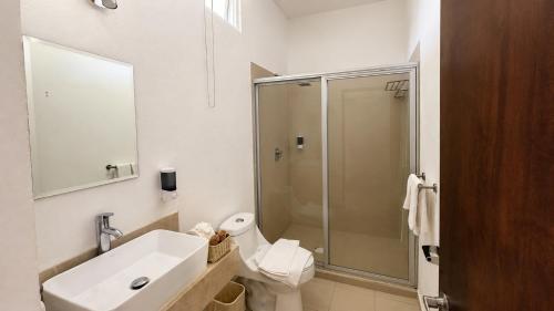 a bathroom with a shower and a sink and a toilet at Hotel y Jardín Las Asadas, Bar y Grill in Xochitepec