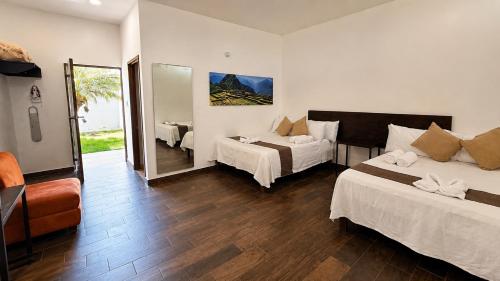 a hotel room with two beds and a mirror at Hotel y Jardín Las Asadas, Bar y Grill in Xochitepec
