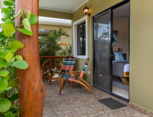 ein Zimmer mit Balkon, Stühlen und einem Bett in der Unterkunft Vidal in Popoyo