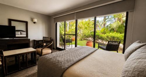ein Schlafzimmer mit einem Bett und einem großen Fenster in der Unterkunft Sina Suites Cancun - Adults Only in Cancún