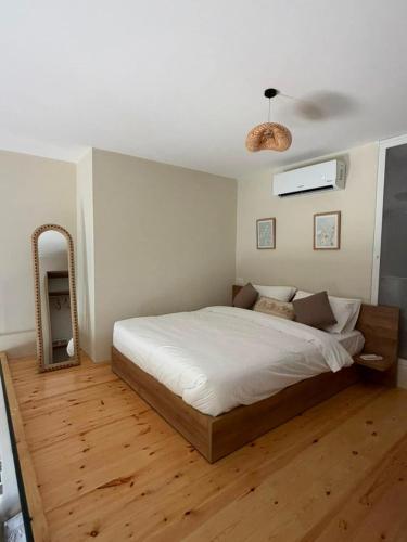 a bedroom with a large bed and a mirror at CBreeze Guesthouse in Batroûn