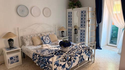 a bedroom with a bed with a blue and white comforter at DIMORA ELIVA in Monopoli