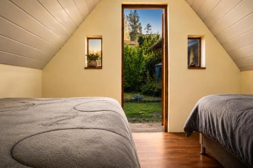 a room with two beds and a window at Ebenezer Salkantay Huts in Colcapampa