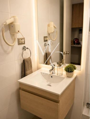 a bathroom with a sink and a mirror at Deptos Estudios y de 2 dormitorios, Central, San Martin 2426. Sector Mall Plaza, Cowork y Factura. in Antofagasta