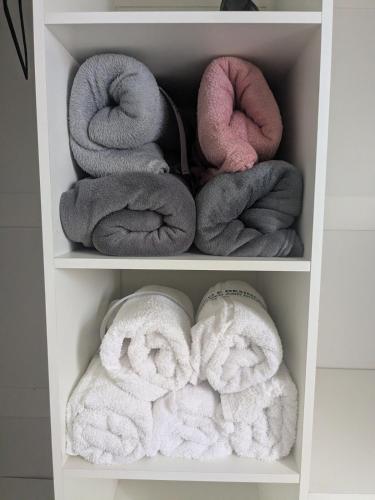 two shelves filled with towels and towels at Casinha Rústica in Indaiatuba