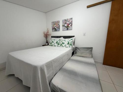 a small bedroom with a bed with a white blanket at Casinha Rústica in Indaiatuba