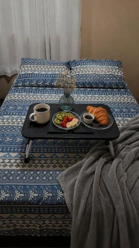 a tray of breakfast foods on a bed at Chalé Romântico Privativo com Lareira e vista para Montanhas in Capela do Alto