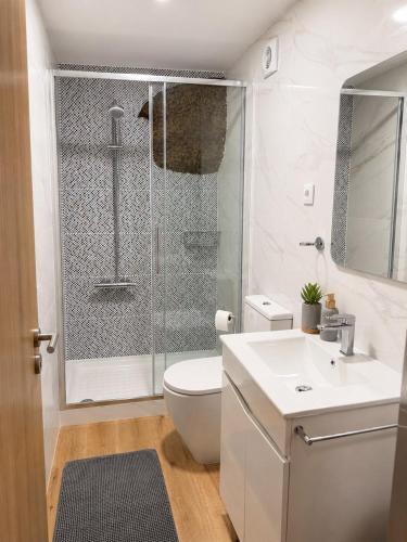 a bathroom with a shower and a toilet and a sink at Refúgio d’Aldeia da Serra in Seia