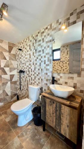 un bagno con WC, lavandino e specchio di Casa IRI - plaja Corbu a Corbu