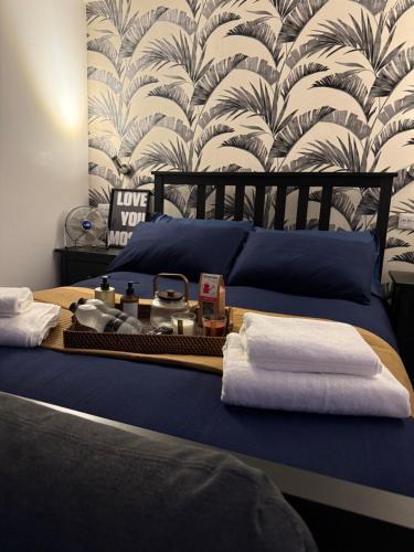 a bedroom with a bed with towels and a wallpaper at Rutland Point in Uppingham
