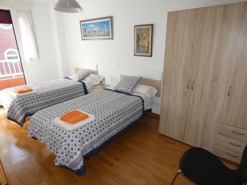 a bedroom with two beds and a cabinet at Vivienda Briviesca La Vega in Briviesca