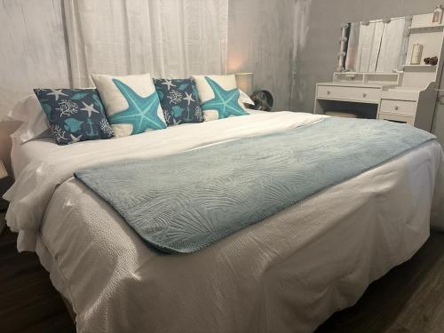 a white bed with blue pillows on top of it at Waterfront Retreat in Slidell