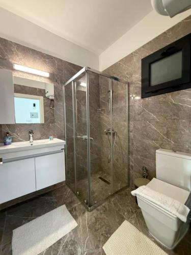 a bathroom with a shower and a toilet and a sink at Caesar Resort & SPA - Apartments Studio in Iskele