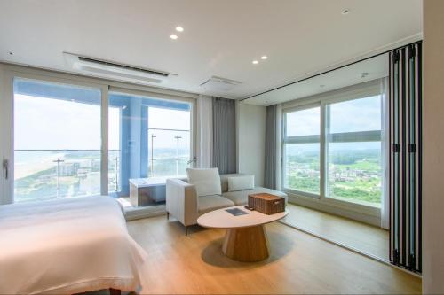 a bedroom with a bed and a couch and a table at 플럼바고올스위트1809 in Sangun-ni