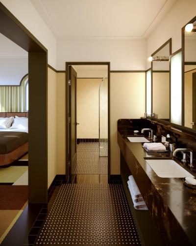 a hotel bathroom with two sinks and a bed at The Warbler in New Orleans