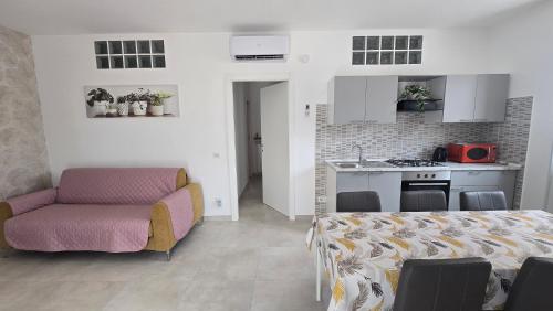 a living room with a couch and a kitchen at Dimora Clorinda 2 in Passo Corese